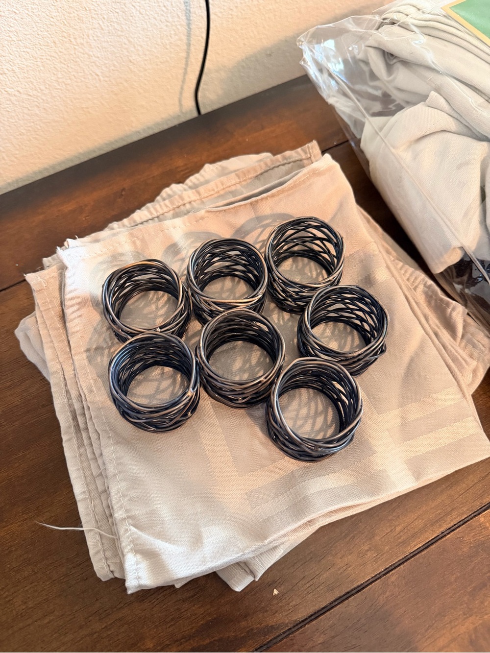 Set of 7 Black bronze Twisted Napkin Rings & beige napkins